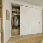 Idée pour fermer un placard sans porte : portes coulissantes blanches en placard